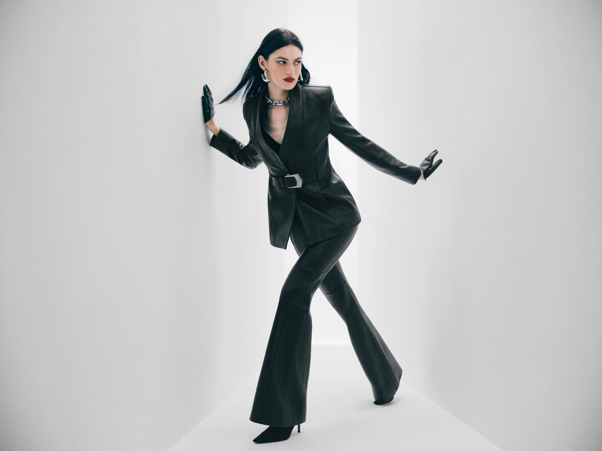 Model dressed in black in a white space